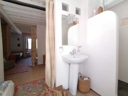 Salle de bain moderne avec lavabo sur piédestal et miroir à la Furanelle B&B à Saint Etienne, avec fixtures blanches et accents en bois