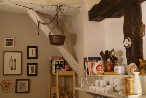 Décor rustique de la cuisine à Casa Peregrinando, Navarrete avec une marmite vintage, poutres en bois et vaisselle espagnole traditionnelle.