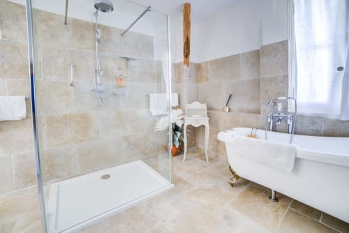 Salle de bain moderne au Manoir Le Coutureau avec douche à l'italienne, baignoire îlot et carrelage de couleurs neutres