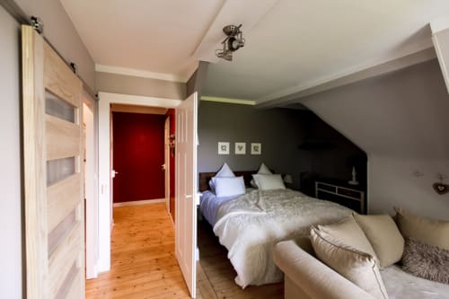 Comfortable double bed with touches of color in the studio Les Rêveurs, a guest room with kitchen in Alsace.