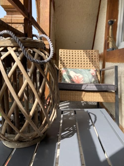 Balcon extérieur privé avec fauteuil de jardin et vue les collines et le jardin avant de la maison d’hôtes Le Clos d’Azel.