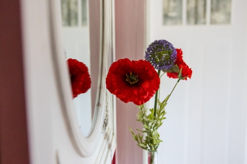 Détail de décoration florale et d’un miroir travaillé situé sur le palier de la maison d’hôtes le Clos d’Azel