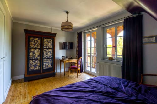 Détails de rangement customisé en toile de Jouy et éclairage chaleureux en pâte de verre année 20 créant une ambiance cocooning  dans la suite.