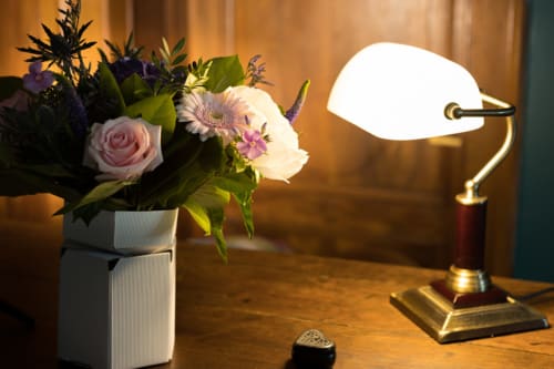 Elegant arrangement at Le Clos d'Azel with fresh flower bouquet and vintage lamp