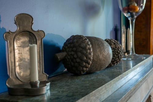 Fireplace decorations in the common room of the guest house Le Clos d'Azel with ornate frame, decorative tassels and pewter candlestick.