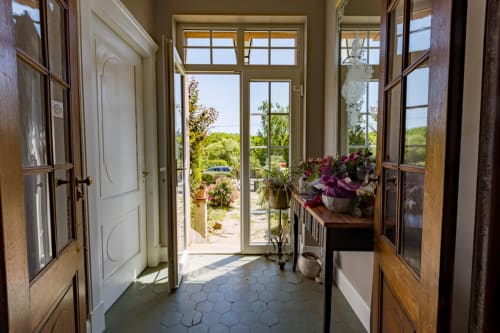 Elegant entrance hall of the Le Clos d'Azel guest house in France with period wooden doors and traditional tiles.