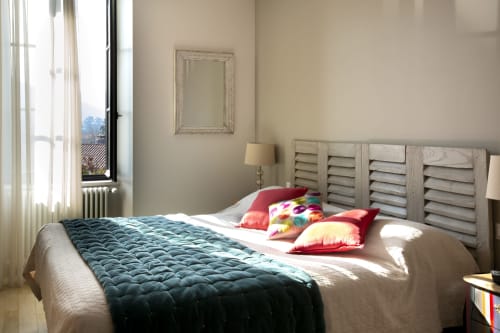 Chambre lumineuse à La Maison De Siloe B&B à Villefranche de Rouergue avec vue sur les montagnes, coussins colorés sur le lit