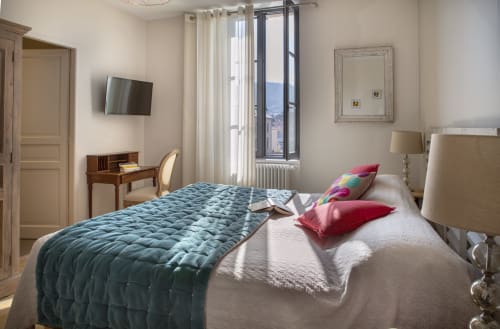 Chambre lumineuse à La Maison De Siloe avec vue montagne, lit matelassé bleu, TV et mobilier crème à Villefranche de