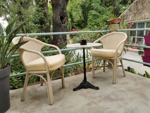 Cozy garden seating area at Domaine à l'Aise in Saint-Pargoire with cream rattan chairs, small table, and lush greenery