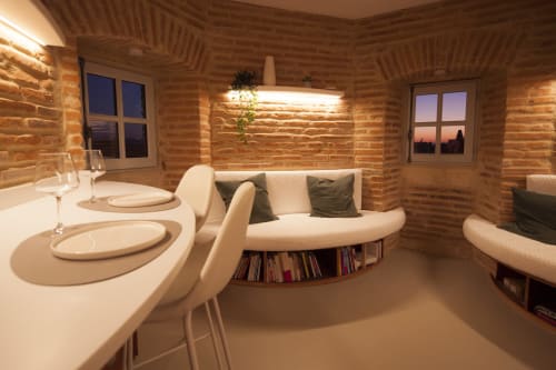 Interno della cabina di legno moderna presso La Tour Du Capitole a Tolosa con zona pranzo, divano curvo e pareti in legno
