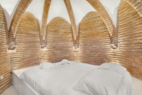 Accogliente alcova camera da letto con biancheria bianca a La Tour Du Capitole BnB a Tolosa, con muri ad arco in mattoni e legno