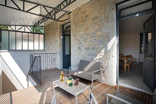 Balcon de chalet moderne à La Maison De Siloe avec coin détente, table à manger et entrée en pierre à Villefranche de