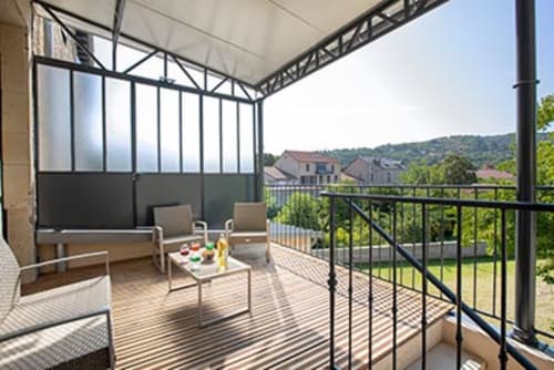 Balcon ensoleillé à La Maison De Siloe avec salon, table et vue sur la campagne près de Villefranche de Rouergue