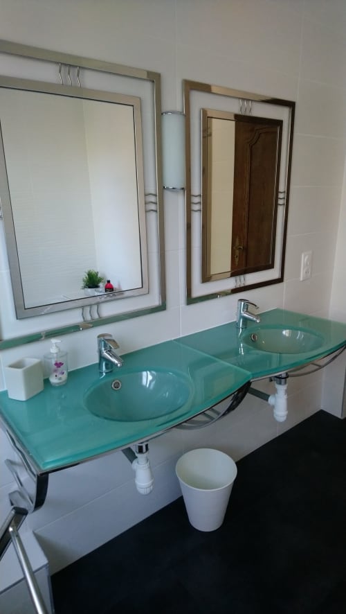 Modernes Badezimmer des Ferienhauses La Tour De L'ill in Straßburg mit doppelten grünen Glassinks und gerahmten Spiegeln