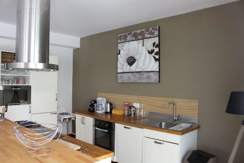 Moderne Cottage-Küche im La Tour De L'Ill Strasbourg mit weißen Schränken, Holzarbeitsplatte und Blumenwandkunst