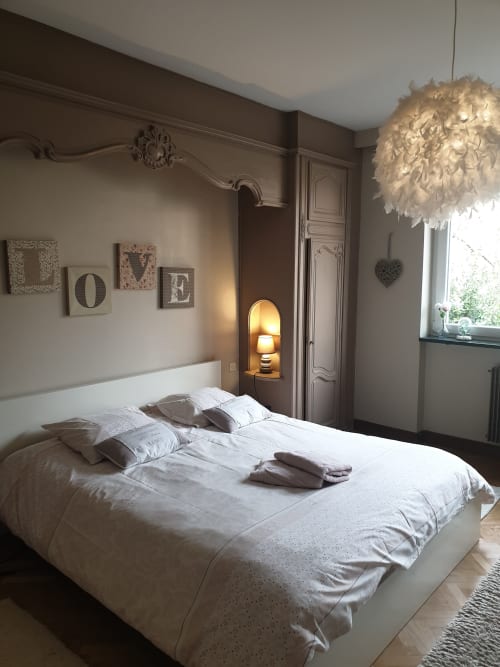 Elegantes Schlafzimmer im Landhaus La Tour De L'ill Strasbourg mit weißem Bett, Federhängeleuchte und Flussblick-Fenster