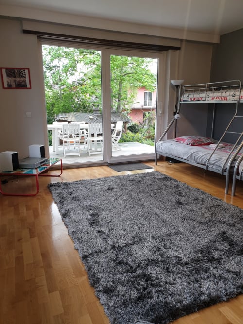 Helles Schlafzimmer im La Tour De L'ill in Strasbourg mit Etagenbett, Flussblick durch Glastüren, Holzböden