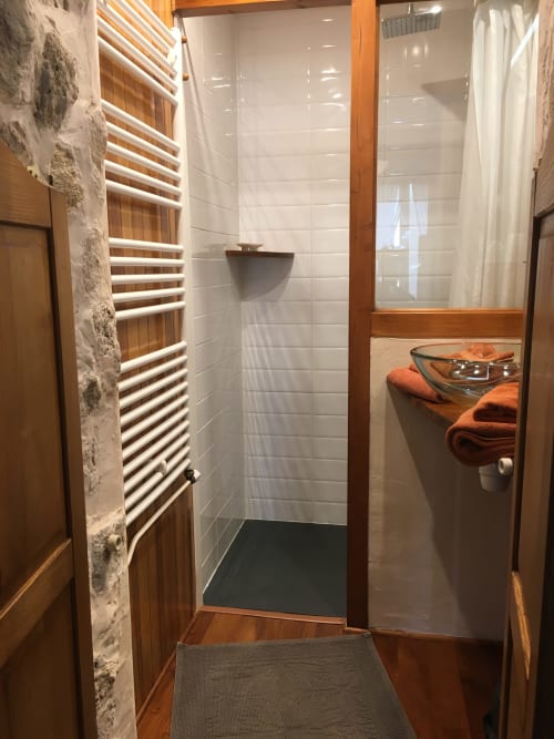 Salle de bain contemporaine aux Sous Les Marronniers : douche à l'italienne, porte-serviettes chauffant et serviettes orange au Petit Palais Cornemps