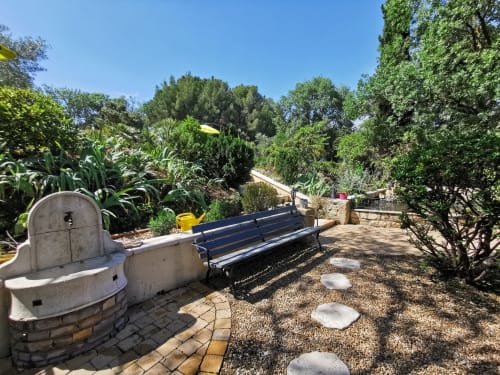 Coin détente ombragé au Domaine à l'Aise B&B à Saint-Pargoire avec banc et végétation luxuriante