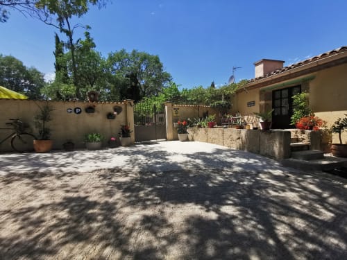 Sonniger Innenhof des Domaine à l'Aise B&B in Saint-Pargoire mit Terrakottagebäuden und Topfblumen