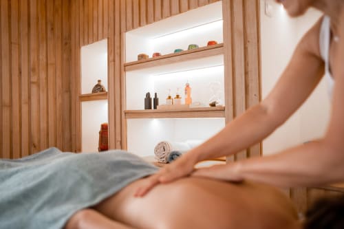 Spa massage therapy at Le Pignié B&B in Lescure-d'Albigeois with wooden shelving displaying wellness products