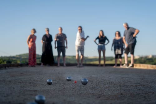 Group playing pétanque outdoors at Le Pignié B&B in Lescure-d'Albigeois, France
