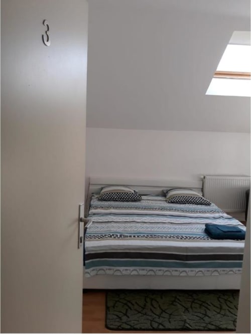 Chambre douillette à la Résidence Mantekila à Marcinelle avec lit, oreillers, puits de lumière, radiateur et décoration épurée
