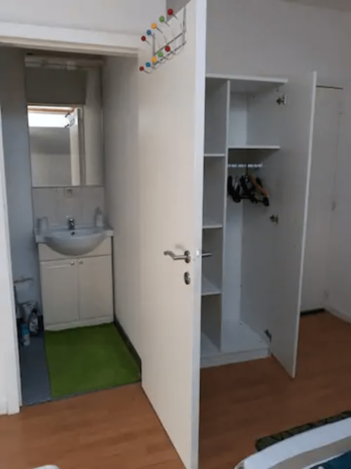 Entrée d'appartement avec lavabo, meuble de rangement et parquet à la Résidence Mantekila, Marcinelle
