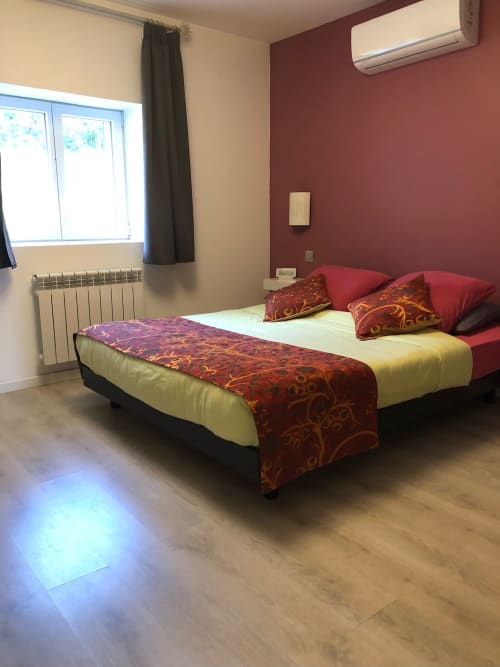 Chambre moderne à La Ferme du Bonheur à Arbigny : lit queen-size, mur accent rouge, climatisation et grande fenêtre