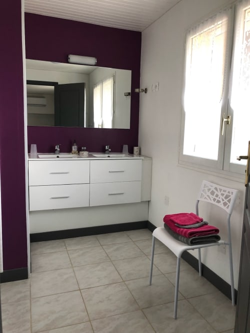 Salle de bains moderne à La Ferme du Bonheur avec double vasque, mur d'accent violet et porte-serviettes chauffant