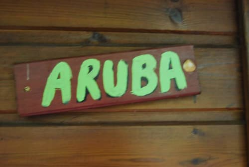Panneau Aruba sur mur en bois à la station Les Hauts De Deshaies en Guadeloupe