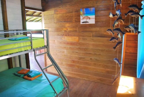 Chambre colorée aux Hauts De Deshaies avec lits superposés, murs en bois et décor marin à Deshaies