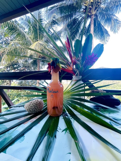 Arrangement floral tropical avec feuilles de palmier à l'hôtel-appartement Les Hauts De Deshaies, Guadeloupe, avec vue sur la mer