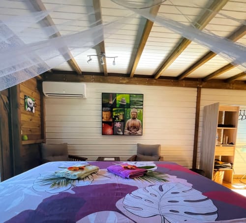 Chambre moderne aux Hauts De Deshaies avec literie colorée, poutres en bois et art mural zen à Deshaies