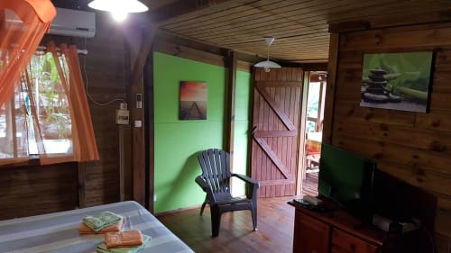 Appartement lumineux aux Hauts de Deshaies avec mur d'accent vert, mobilier bois et vue sur mer à Deshaies, Guadeloupe