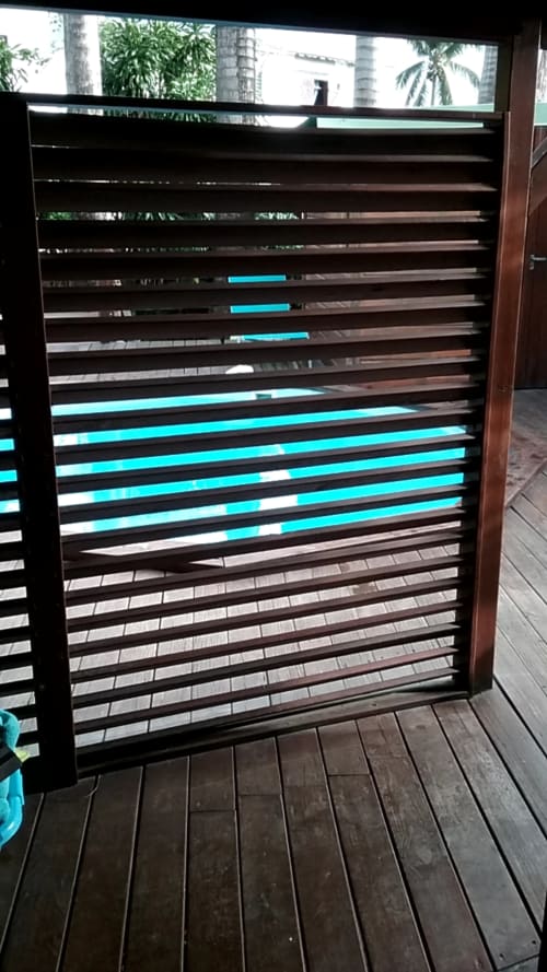 Portail à lames horizontales modernes avec accents turquoise au gîte Les Hauts De Deshaies, vue tropicale
