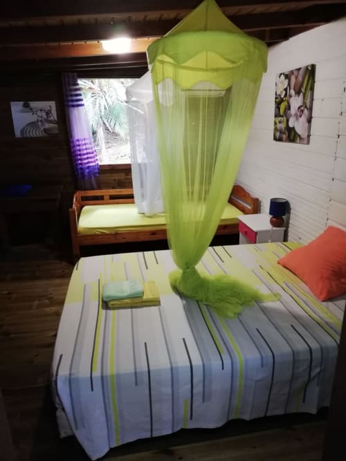 Ciel de lit en moustiquaire vert vif au-dessus du lit, chambre de la villa Les Hauts De Deshaies, Deshaies