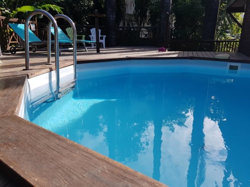 Piscine d'un bleu cristallin avec échelle métallique à l'hôtel-cottage Les Hauts De Deshaies à Deshaies, Guadeloupe