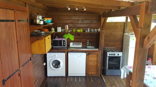 Cuisine du cottage aux Hauts de Deshaies avec intérieur bois, lave-linge, cuisinière, réfrigérateur et accès à la vue mer