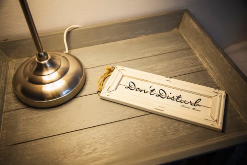 Plateau en bois avec panneau "Ne pas déranger" et lampe dans la chambre d'hôtes de Casa Rural La Perla