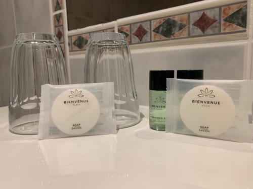 Bienvenue Paris soap and toiletries on bathroom counter at Le Moulin Des Ramiers hotel