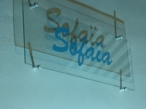 Enseigne en verre « Sayka Sayka » fixée au mur blanc de la chambre d'hôtes Kaz A Bibi à Sainte-Rose, Guadeloupe
