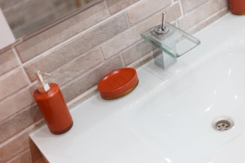 Lavabo moderne avec distributeur de savon rouge et accessoires à la villa Kaz A Bibi, Sainte-Rose, Guadeloupe