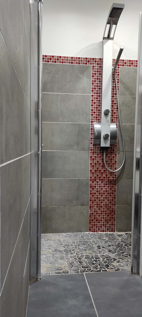 Salle de douche moderne avec mur en carrelage mosaïque rouge et pluie de tête au gîte Kaz A Bibi à Sainte-Rose
