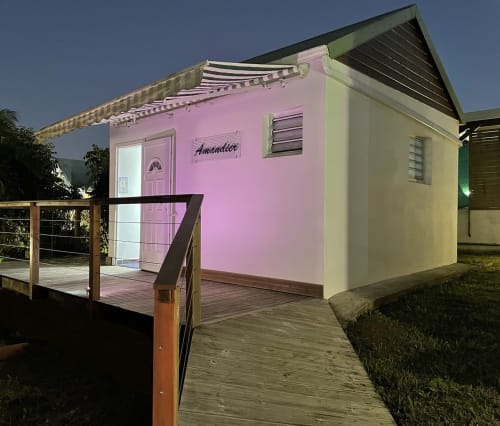 Cottage rose « Amandier » à la pension Kaz A Bibi à Sainte-Rose, Guadeloupe avec terrasse et auvent en bois