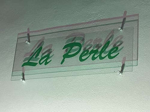 Panneau lumineux « La Perle » fixé au mur du bungalow avec vue piscine à Kaz A Bibi, Sainte-Rose