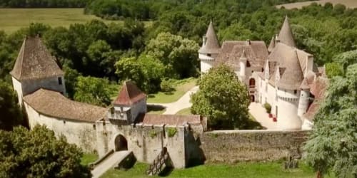 Manoir Le Coutureau, une demeure médiévale de style château en Dordogne, entourée de jardins luxuriants et d'arbres