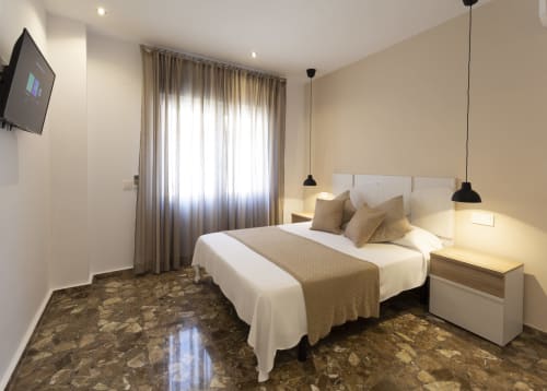 Habitación moderna de Room Boutique 32 Denia con camas gemelas, balcón con vista a la ciudad y decoración contemporánea
