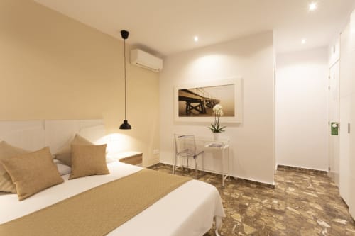 Modern bedroom at Room Boutique 32 hostel in Denia with bed, desk, AC, and city views