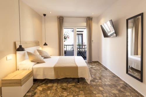 Modern bedroom at Room Boutique 32 hostel in Denia with double bed, balcony, TV, and city views
